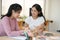 Female employee training her colleague to analyse financial data