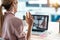 Female employee waving and speaking on video call with diverse colleagues on online briefing with laptop at home