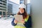 Female engineer or architect stands outdoors with tablet. Supervisor wearing safety helmet while working in a building