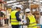 Female engineer and male supervisor standing in modern industrial factory, talking about production. Team management in