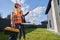 Female engineer pointing at house to worker with toolkit