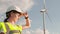 A female engineer straightens her helmet and focuses on analyzing data and controlling the process of generating