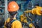 A female engineer in uniform and a protective helmet, holding a tablet and conducting an inspection of the equipment. The view