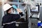 Female engineer wearing protective mask and glove to protect against Covid-19 and looking at robot CNC machine in smart factor