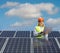 Female engineer working on a laptop computer behind solar panels