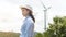 Female engineer working on the seaside wearing a protective helmet over electrical turbines background