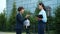 Female entrepreneurs chatting outdoors shaking hands saying good-bye and leaving