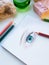 Female eye drawn colorful pensils surrounded with cozy objects