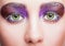 Female face with green pistachio colour eyes, evening violet purple eyes shadows and white eyelashes makeup