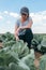 Female farmer agronomist examining white cabbage crop plant development in vegetable garden