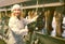 Female farmer in barn with cow milking machines