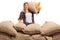 Female farmer behind a pile of burlap sacks