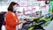 Female farmer choosing garden shears in store during pandemic