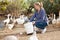 Female farmer feeding domestic fowl