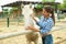 Female farmer feeds horse in the corral