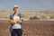 Female farmer in a field with a tractor behind