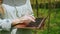 Female farmer with laptop inspecting gourd harvest on vegetable farm, typing on keyboard. Woman agronomist checks