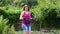 Female farmer looking at camera and carrying plastic box with eggplants