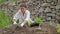 Female farmer planting salad greens in raised garden beds