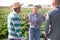 Female farmer reprimanding male workers in farm field