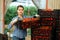 Female farmer stacks boxes with ripe tomatoes in the backyard