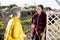 Female farmers friendly talking outside next to wooden fence on background with farm