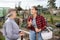 Female farmers friendly talking outside next to wooden fence on background with farm