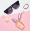 Female fashion accessories on a pink white pastel background. Sunglasses, perfume bottle, shells. Summer beach accessories. Top vi
