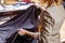 Female fashion designer working on suiting fabric with dressmaking accessories on table