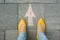 Female feet with arrow painted on the grey sidewalk