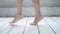 Female feet close-up. The girl walks barefoot on the wooden floor