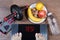 Female feet on digital scales with word yes surrounded by sport accessories AB roller wheel, fitness gloves, plate with fruits