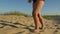 Female feet goes barefoot on the sand at the beach.