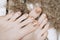 Female feet with golden nail design. Glitter gold nail polish pedicure on wooden background. Autumn pedicure