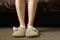 female feet in gray slippers on the carpet in the bedroom, feet in slippers, comfort