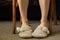 Female feet in gray slippers on the carpet in the bedroom, feet in slippers, comfort
