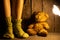 Female feet in knitted socks on the floor next to a teddy bear poured the lamp