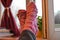 Female feet in pink woolen socks by the window, retro style tonal correction photo filter