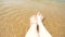 Female feet on the sand, the sea wave covers the female legs. 4k, slow motion