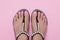 Female feet in sandals, pink pedicure. Woman summer shoes. Nail care concept, chiropody