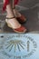 Female feet with sandals on the symbol of the Camino de Santiago