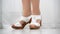 Female feet shod in white leather clogs