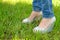 Female feet in shoes with wedge heels on green grass