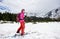 Female feet in ski boots. Backpacker moving at ski touring. White sky, mountain view. Copy space. Low angle side view