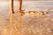 Female Feet soaking in the beach sand. orange golden sunlight