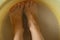 Female feet in soapy water, washing in a plastic bowl