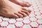 Female feet standing on acupressure mat.