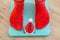Female feet standing on electronic scales for weight control in red socks with Christmas santa hat