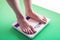 Female feet standing on mechanical scales for weight control. Concept of slimming and weight loss