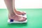 Female feet standing on mechanical scales for weight control. Concept of slimming and weight loss